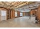 Unfinished basement with exposed beams, framed walls, and walk out door at 1312 Preserve Park Dr, Loganville, GA 30052