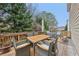 A wooden deck is furnished with an outdoor table and chairs, ideal for relaxing and enjoying the surrounding views at 1312 Preserve Park Dr, Loganville, GA 30052