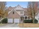 Two-story brick and siding home featuring an attached two-car garage and a covered front porch at 1312 Preserve Park Dr, Loganville, GA 30052