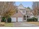 Two-story brick and siding home featuring an attached two-car garage and a covered front porch at 1312 Preserve Park Dr, Loganville, GA 30052