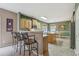 Eat-in kitchen featuring an island, wood cabinets, a bar, and a tile floor at 1312 Preserve Park Dr, Loganville, GA 30052
