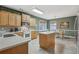 Sunlit kitchen boasts a large island, light wood cabinets, a tile floor, and a dining area at 1312 Preserve Park Dr, Loganville, GA 30052