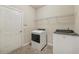 Convenient laundry room with washer, dryer, tile flooring, and wire shelving at 1312 Preserve Park Dr, Loganville, GA 30052
