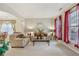 Inviting living room with neutral carpet, large windows with red drapes and comfortable beige sofas at 1312 Preserve Park Dr, Loganville, GA 30052