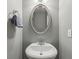 Powder room includes a pedestal sink, an oval mirror, and gray walls at 1312 Preserve Park Dr, Loganville, GA 30052