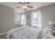 This bedroom features neutral walls and carpet, a ceiling fan, and two windows with curtains and lots of natural light at 1703 Prospect Way, Conyers, GA 30094