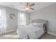 This bedroom features neutral walls and carpet, a ceiling fan, and a window with curtains and lots of natural light at 1703 Prospect Way, Conyers, GA 30094