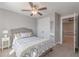 This bedroom features neutral walls and carpet, a ceiling fan, a closet, and a doorway to an adjacent room at 1703 Prospect Way, Conyers, GA 30094