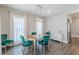 Dining room with a wooden table, upholstered chairs, chandelier, and large windows with sheer curtains at 1703 Prospect Way, Conyers, GA 30094