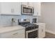 Close up of a modern kitchen with white cabinets, quartz countertops, and stainless steel appliances at 1703 Prospect Way, Conyers, GA 30094