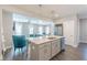 Open kitchen with stainless steel appliances and a spacious island flowing into the living area at 1703 Prospect Way, Conyers, GA 30094