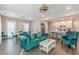 Bright living room featuring teal sofa, dining table, wood floors, and modern lighting fixtures at 1703 Prospect Way, Conyers, GA 30094