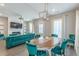 Open-concept living area with a dining table, fireplace, TV, and a comfortable, stylish velvet sofa at 1703 Prospect Way, Conyers, GA 30094
