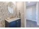 Chic powder room with floral wallpaper, round mirror, navy blue vanity, and elegant fixtures at 1703 Prospect Way, Conyers, GA 30094