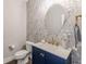 Stylish powder room featuring floral wallpaper, navy vanity, and a round mirror at 1703 Prospect Way, Conyers, GA 30094