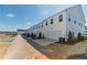 View of rear exterior of multiple townhomes and yards with landscaping and rear parking at 1703 Prospect Way, Conyers, GA 30094
