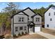 Charming two-story home with gray siding, black trim, white garage door, and a well-manicured lawn at 3195 Tackett Rd, Douglasville, GA 30135