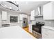 Open kitchen featuring a white island, stainless steel appliances, and quartz countertops at 3195 Tackett Rd, Douglasville, GA 30135