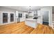 Spacious kitchen featuring stainless appliances, white cabinets, and an island with hardwood flooring at 3195 Tackett Rd, Douglasville, GA 30135