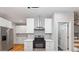 Kitchen with stainless appliances, range hood, white cabinetry, and hardwood floors at 3195 Tackett Rd, Douglasville, GA 30135