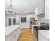Beautiful kitchen showcasing white cabinets, stainless steel appliances, hardwood floors and a center island at 3195 Tackett Rd, Douglasville, GA 30135