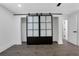 Bright bedroom featuring wood-look floors, white walls and a black framed sliding door with glass panels at 3850 Crosby Nw Dr, Atlanta, GA 30331
