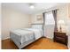 Cozy bedroom featuring a comfortable bed, a wooden nightstand with lamp, and a patterned curtain at 147 Windy Hill Sw Rd, Marietta, GA 30060