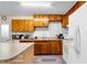 A view of the kitchen featuring wood cabinets, white appliances, and laminate countertops at 147 Windy Hill Sw Rd, Marietta, GA 30060