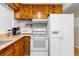 A view of the kitchen featuring wood cabinets, white appliances, and laminate countertops at 147 Windy Hill Sw Rd, Marietta, GA 30060
