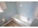 Bathroom with a tub and shower featuring blue tiled walls and modern fixtures at 3894 Summit Dr, Douglasville, GA 30135