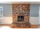 Living room featuring a large brick fireplace with a wooden mantel and light hardwood floors at 3894 Summit Dr, Douglasville, GA 30135