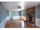 Spacious living room with hardwood floors and a charming brick fireplace, perfect for cozy evenings at 3894 Summit Dr, Douglasville, GA 30135