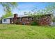 Rear exterior view of brick home with metal roof, including patio and yard at 3894 Summit Dr, Douglasville, GA 30135