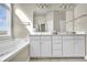 Bright bathroom featuring a double vanity, large mirror, soaking tub, and natural light from a large window at 4198 Haynes Mill Nw Ct, Kennesaw, GA 30144