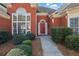 Inviting front entrance with red door, large windows, and manicured shrubs at 4198 Haynes Mill Nw Ct, Kennesaw, GA 30144