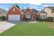 Charming red brick home featuring an attached two-car garage and a well-manicured green front lawn at 4198 Haynes Mill Nw Ct, Kennesaw, GA 30144