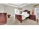 Elegant main bedroom with tray ceiling, carpet flooring, and dark wood furniture at 4198 Haynes Mill Nw Ct, Kennesaw, GA 30144