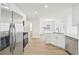 Modern kitchen features stainless steel appliances, wood-look flooring, and sleek white cabinetry at 10 Dairyland Dr, Covington, GA 30016