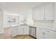 Modern kitchen with stainless steel appliances, white cabinetry, and wood-look flooring at 10 Dairyland Dr, Covington, GA 30016