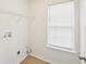 Well lit Laundry room with hookups, shelving, and hardwood flooring at 10 Dairyland Dr, Covington, GA 30016