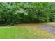 Private backyard surrounded by lush trees and greenery, with a concrete pad and grassy area at 2524 Oakleaf Rdg, Lithonia, GA 30058