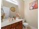 Well-lit half bathroom with a decorative mirror, artwork and a dark wood vanity at 2524 Oakleaf Rdg, Lithonia, GA 30058