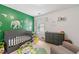 Bedroom with whimsical animal wall decor, gray crib and dresser set, and cozy chair at 2524 Oakleaf Rdg, Lithonia, GA 30058