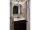 Modern bathroom features a dark vanity, a large arched mirror, and a textured brick accent wall at 3133 Rebecca St, Covington, GA 30014