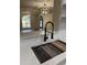 Close-up of a kitchen sink with black faucet, quartz countertops, and view into the open concept living area at 3133 Rebecca St, Covington, GA 30014