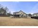 Wide shot of the home's backyard with a large lawn and covered outdoor patio at 3492 Maple Hill Rd, Lithonia, GA 30038