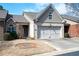 Charming townhome with a two-car garage, tan brick facade, and well-maintained landscaping at 3832 Abbott Ln # 1, Powder Springs, GA 30127