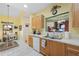 Sunny kitchen with wood cabinets, white appliances, and a view into the living area at 3832 Abbott Ln # 1, Powder Springs, GA 30127