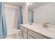 Bright bathroom with a double sink vanity, white cabinets, gold hardware, and tiled shower at 4450 Heatherwood Sw Dr, Atlanta, GA 30331