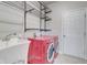 Convenient laundry room with a sink, shelving and a modern, vibrant red washer and dryer at 4450 Heatherwood Sw Dr, Atlanta, GA 30331